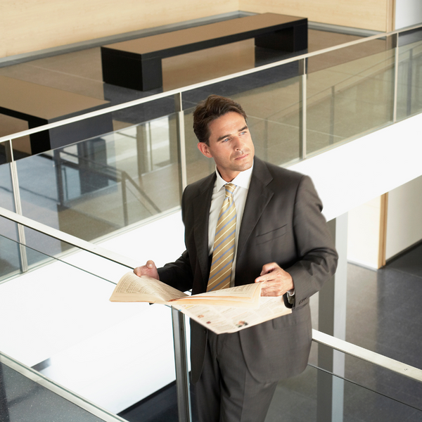 man standing by glass railing