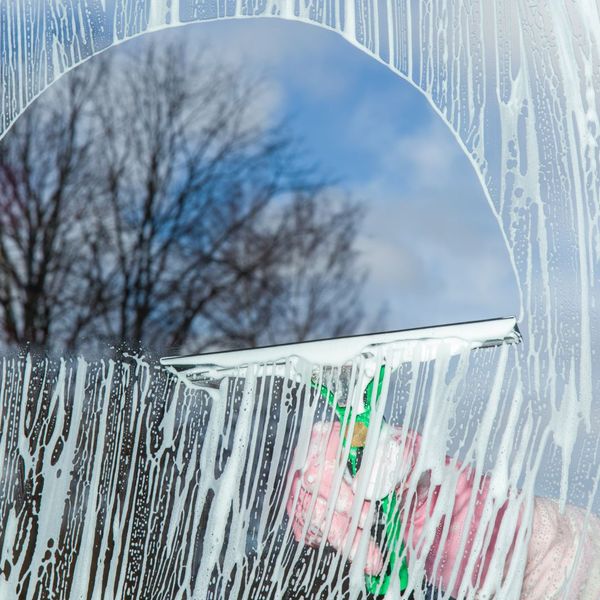 using a squeegee to clean a home window