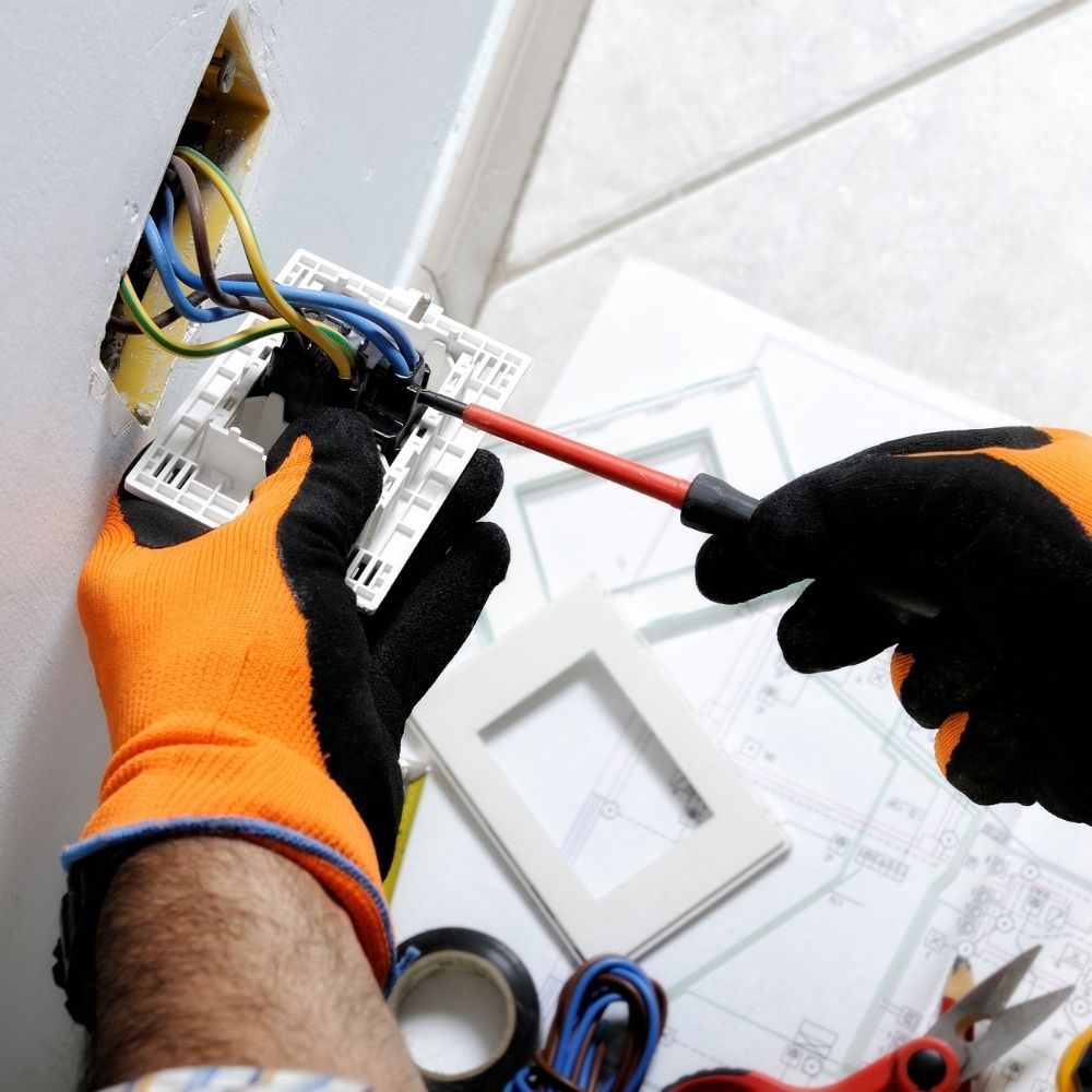 An electrician installing a plug An electrician installing a plug