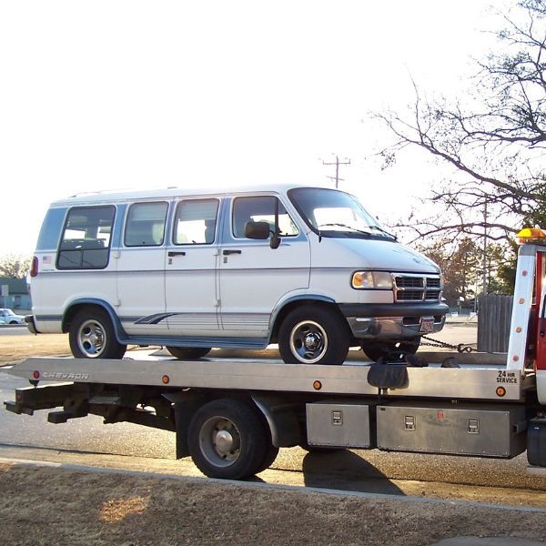 Van on the back of a tow truck