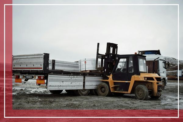 A forklift lifts a large truck trailer A forklift lifts a large truck trailer