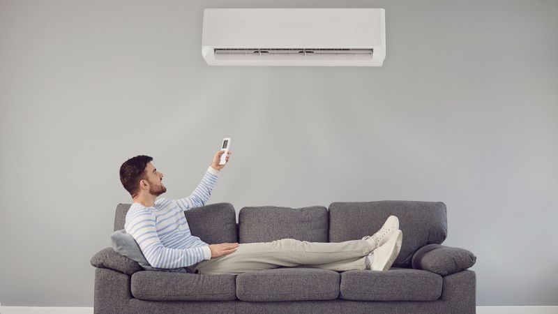 man using a remote to control his AC 