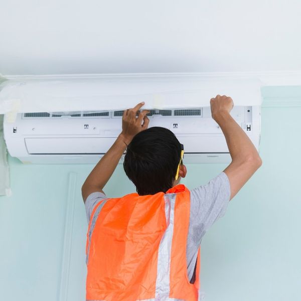 Tech checking an AC unit