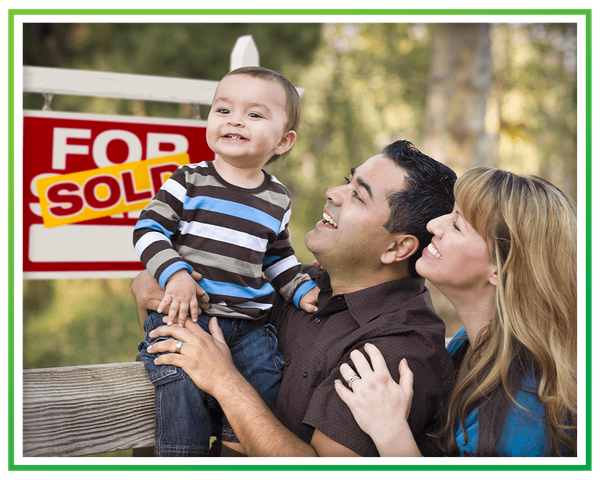 a family in front of a Sold sign