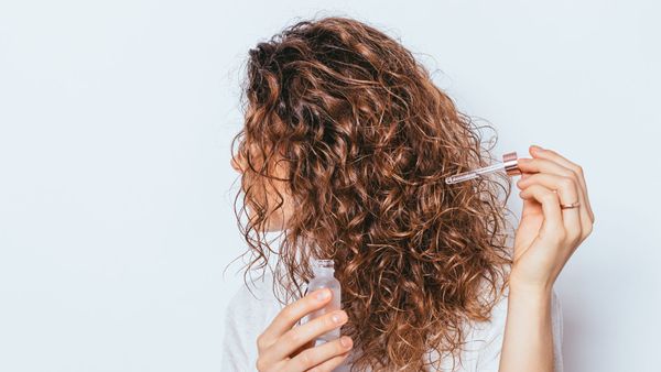 Woman applying oil to her hair