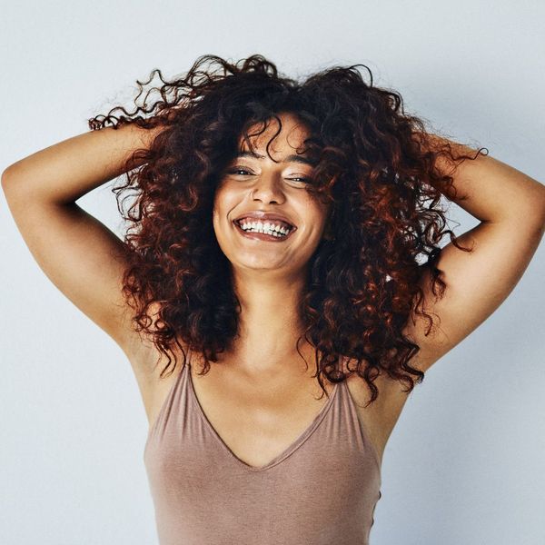 Woman smiling with her hands in her hair