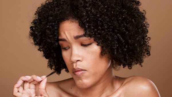 A girl looks at her natural hair