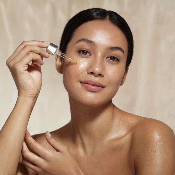 woman putting serum on her face