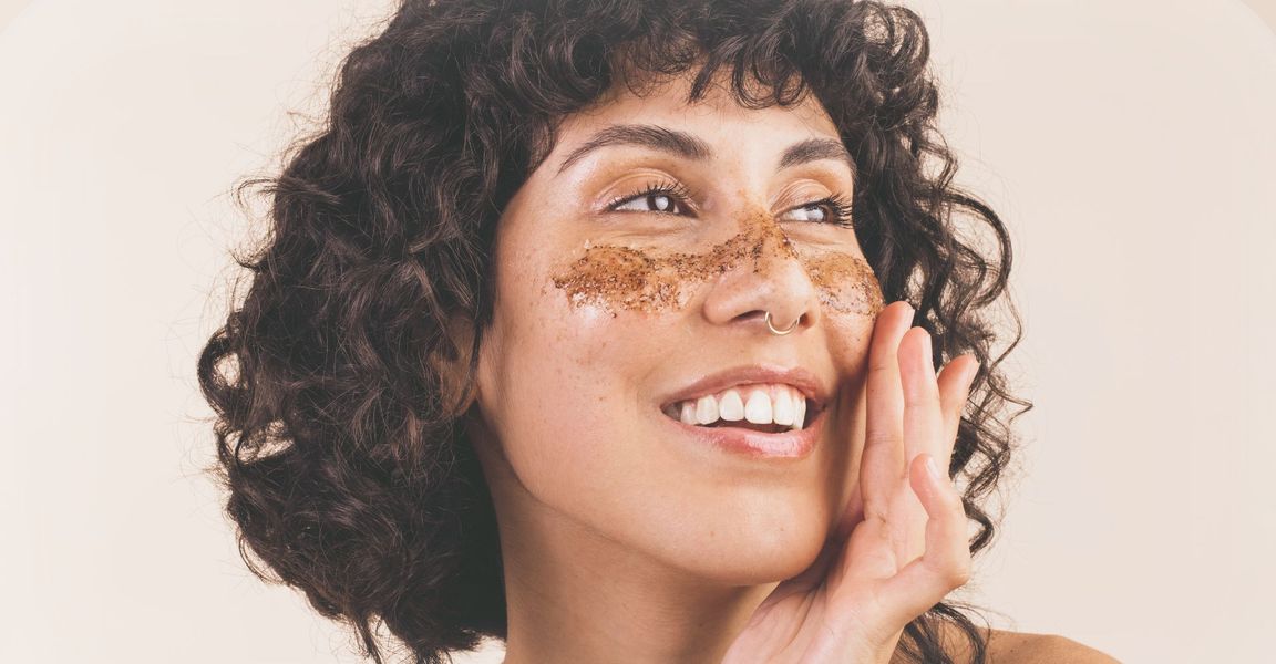 woman smiling with exfoliation mask