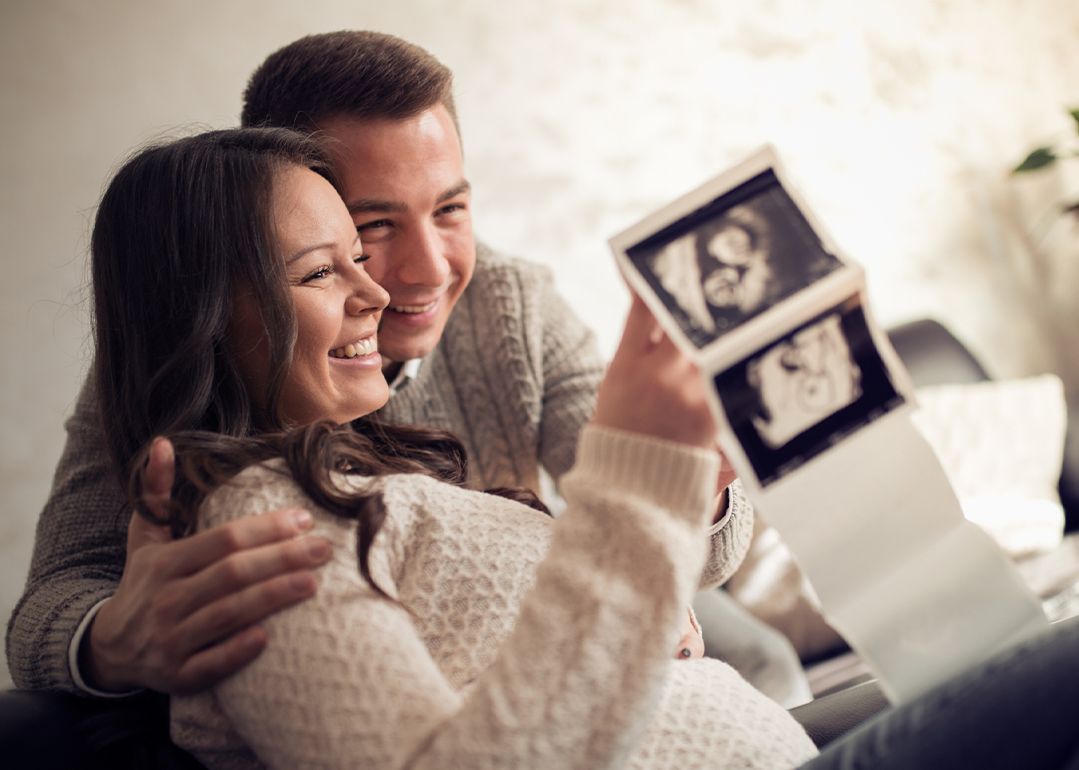 parents looking at ultrasound images smiling