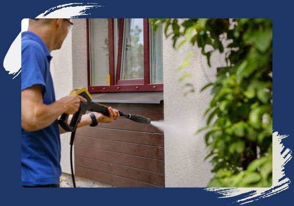 man power washing side of house