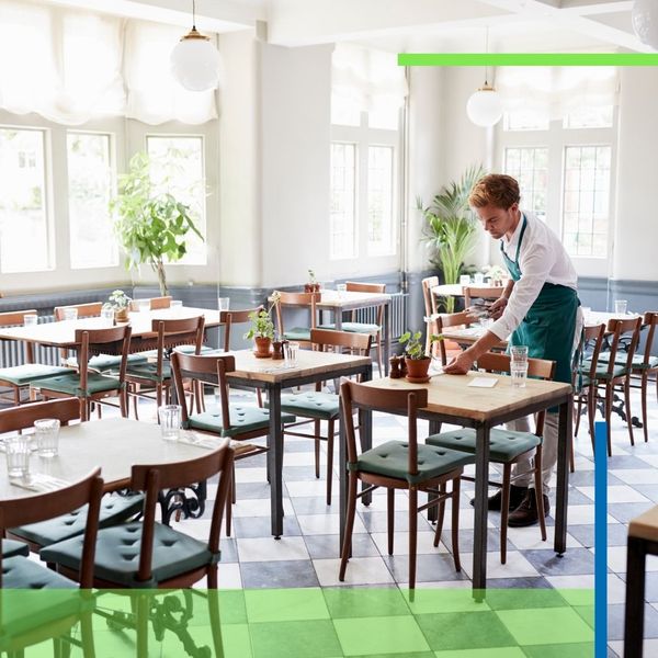 restaurant employee sets table in dining room