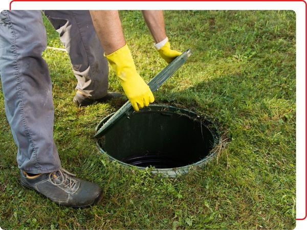 man with gloves on opening manhole