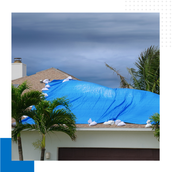 roof with blue tarp over damaged area 
