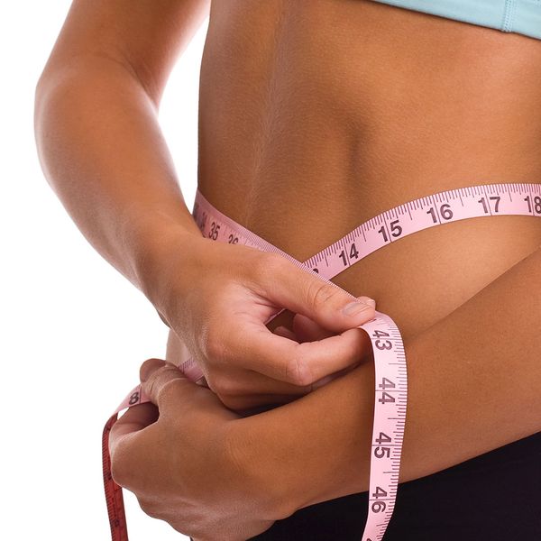 fit woman measuring waste size