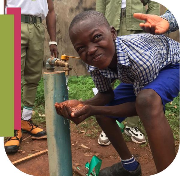 Little boy smiling near water spigot