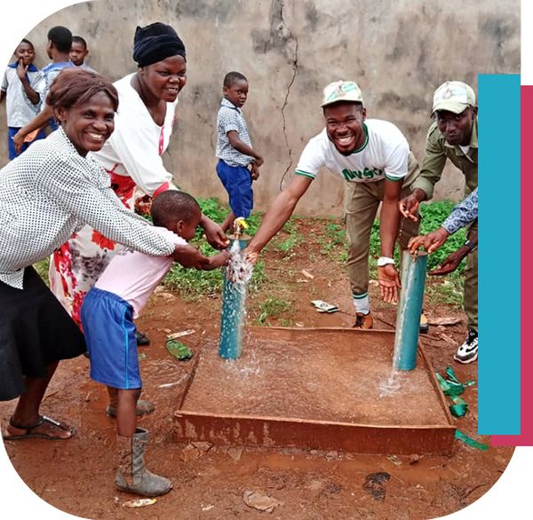 People smiling near water spigot