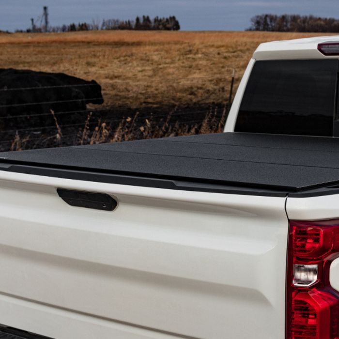 White truck with a black cover over its bed