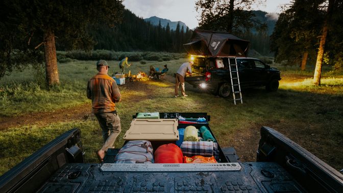 Group setting up camp with gear from their truck bed