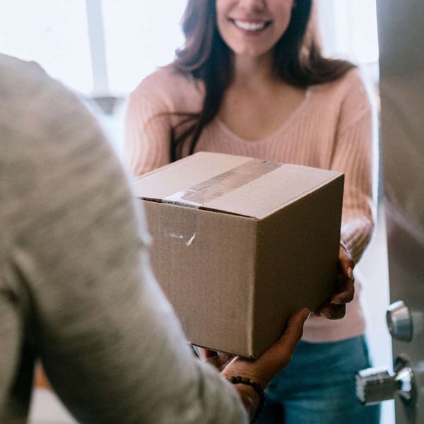 woman handing package to delivery driver