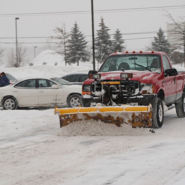 truck shoveling parking lot snow