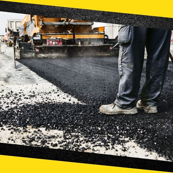 A contractor standing on freshly paved asphalt