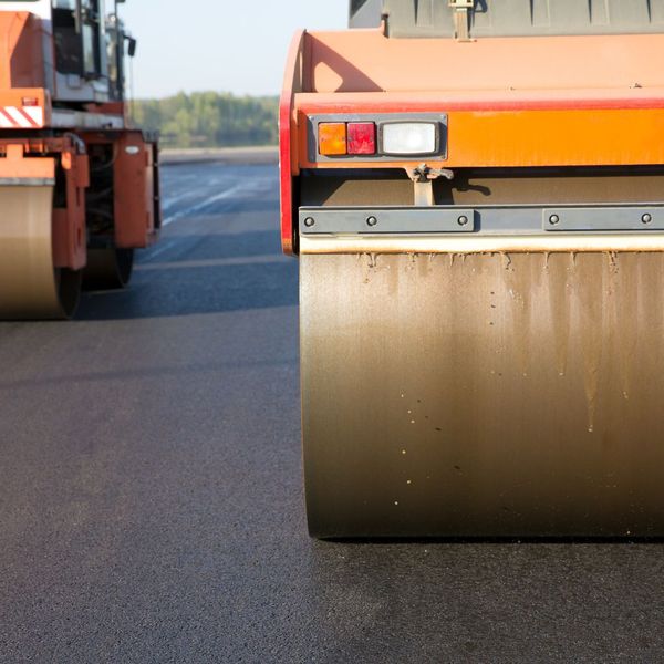 two machines paving asphalt