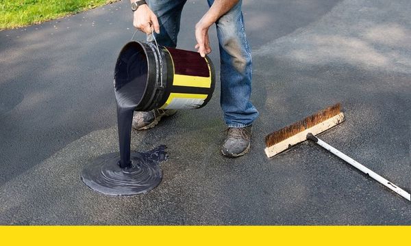 seal coating being poured onto driveway