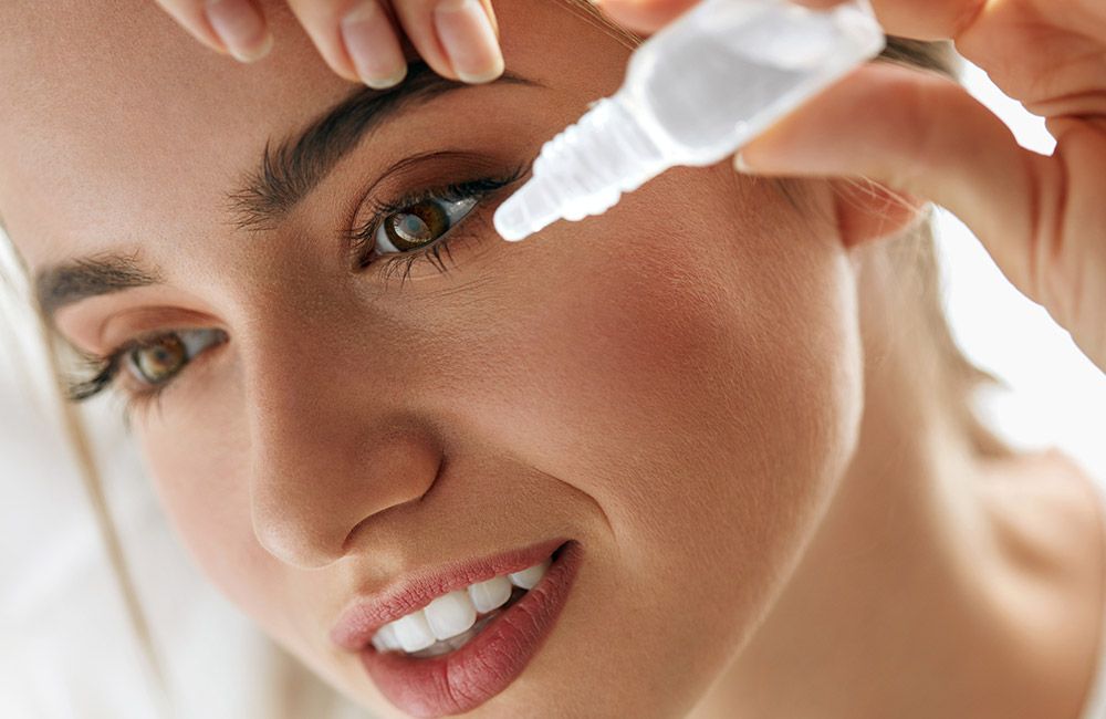 Photo of a woman putting in eye drops Photo of a woman putting in eye drops