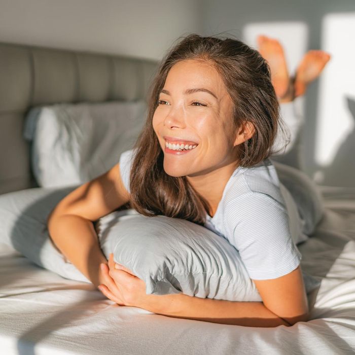 smiling woman laying in bed