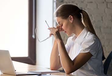 woman rubbing her eyes