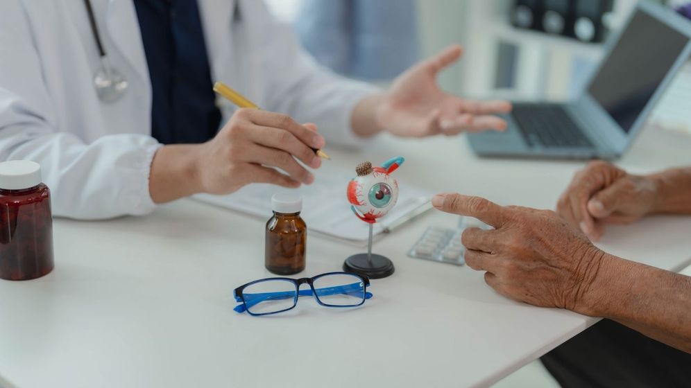 Image of a doctor with a model of an eye Image of a doctor with a model of an eye
