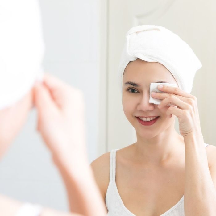 Woman removing eye makeup with a cotton pad