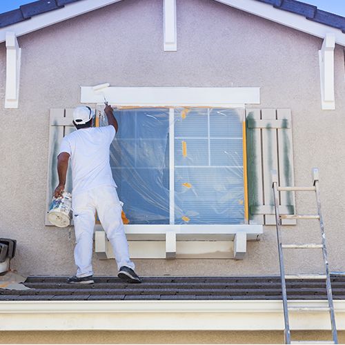 Man painting the trim on windows