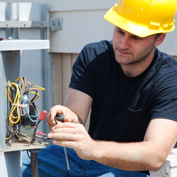 hvac tech repairing a commercial ac unit