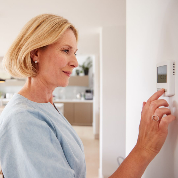 woman setting thermostat