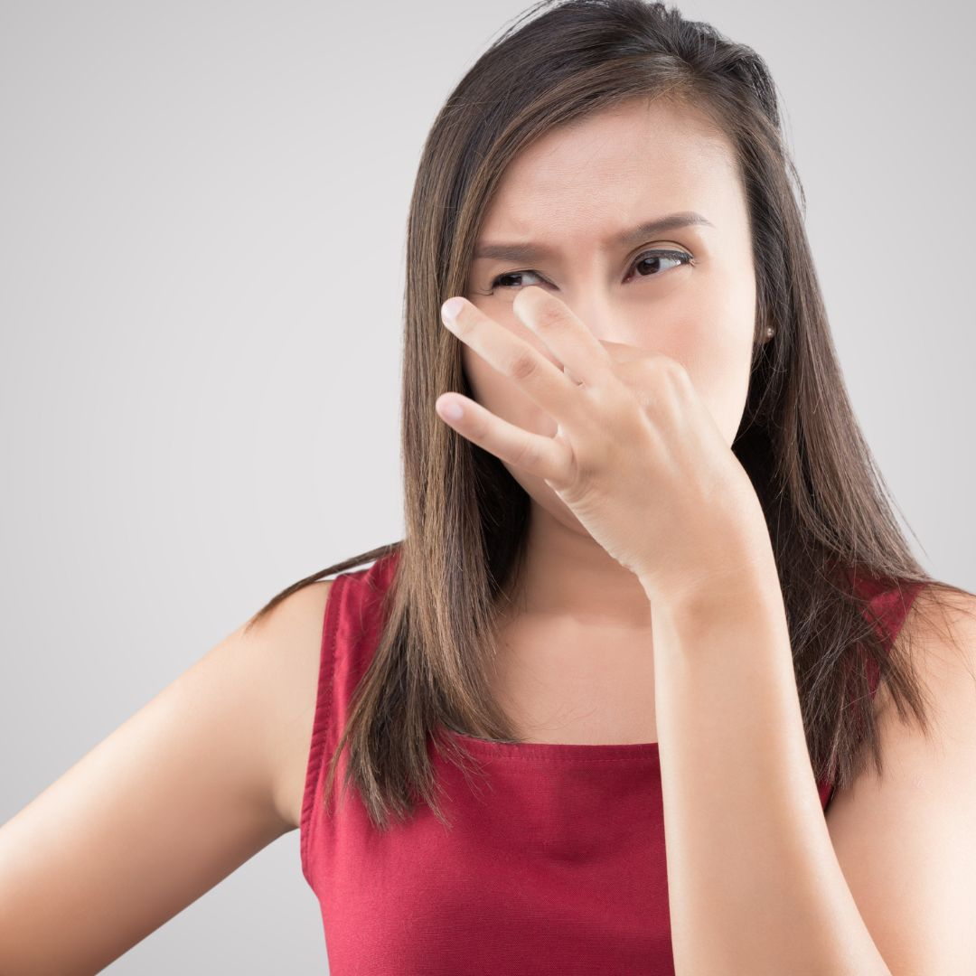 Woman holding her nose because of an unpleasant smell