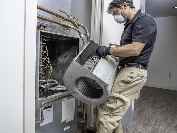 An HVAC repair man fixing a unit