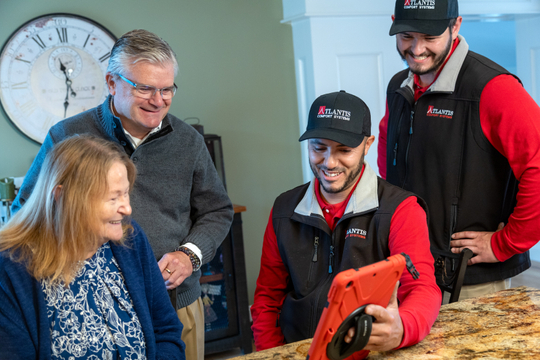 Atlantis Comfort Systems HVAC technicians explaining a residential heating and air conditioning project to a homeowner in Rhode Island before installation or repair services. Residential HVAC Consultation in Rhode Island