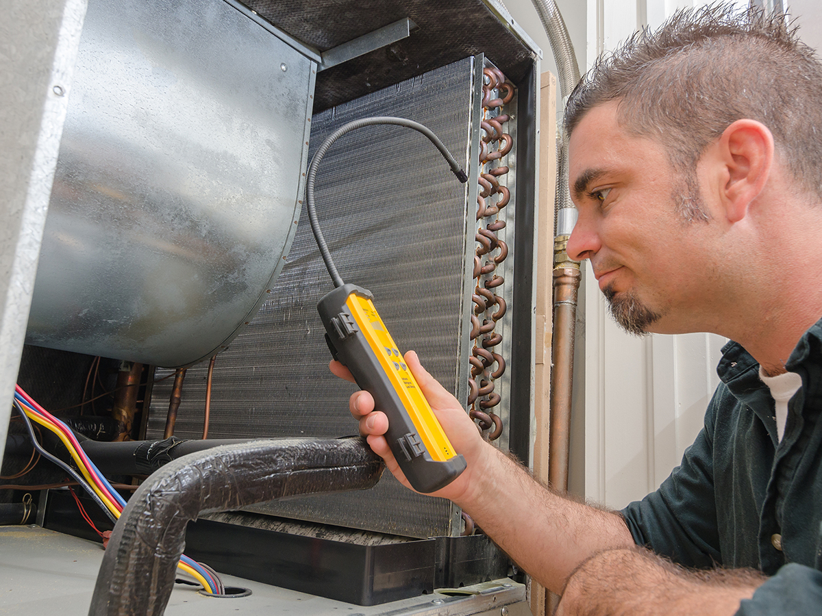 Man checking the evaporator coils in ac unit