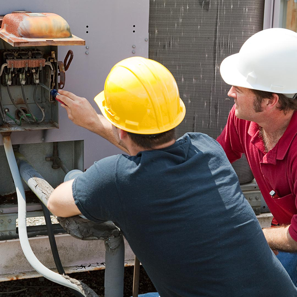 hvac technicians repairing a commercial ac unit