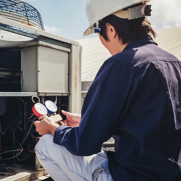 hvac tech inspecting a commercial ac unit