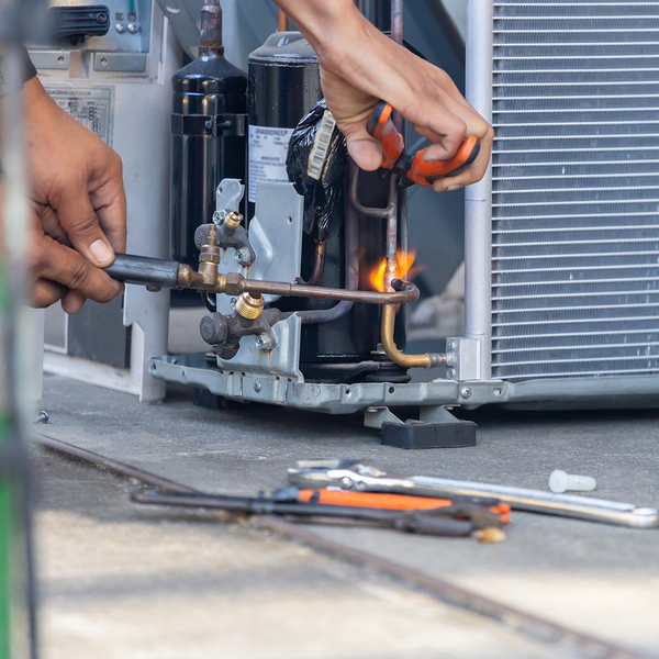 hvac technician repairing an ac unit