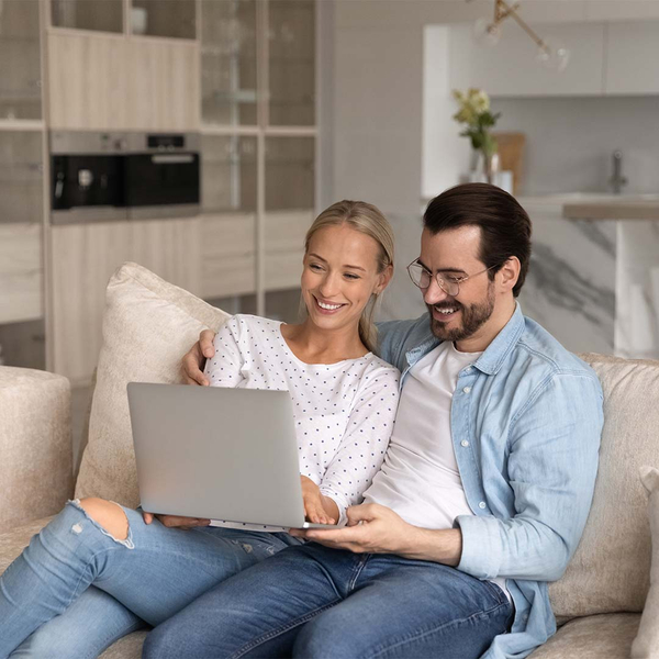happy comfortable couple looking at laptop