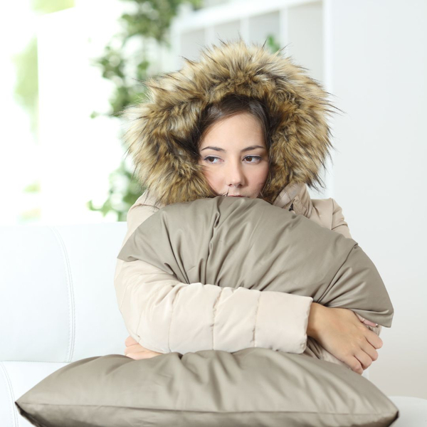 woman in coat cold at home