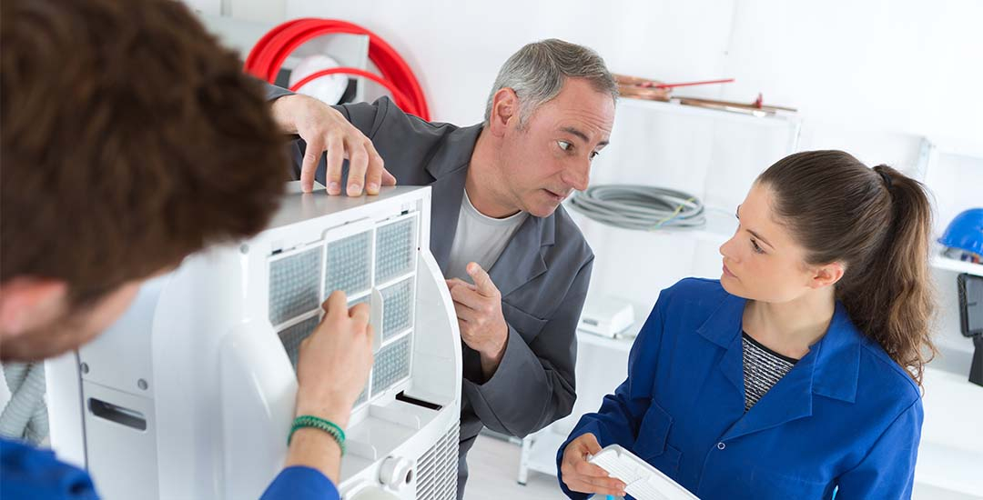 HVAC workers discussing repair near unit