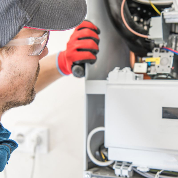 repair tech looking at furnace