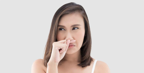 Young lady holding finger up to nose
