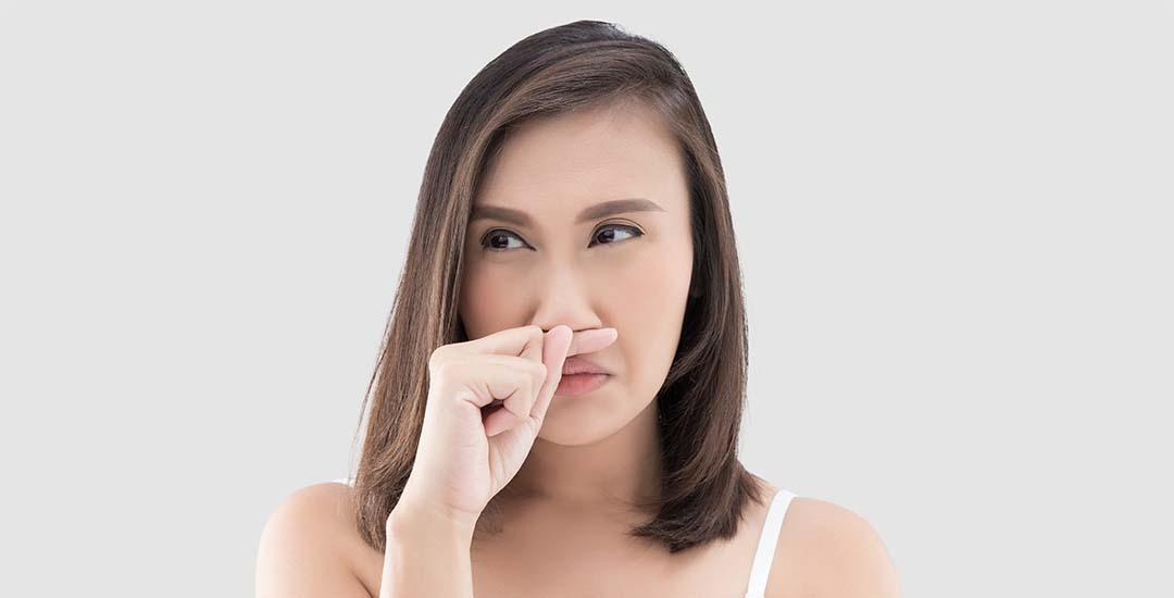 Young lady holding finger up to nose