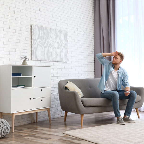 man sitting on couch, sweating from poor AC